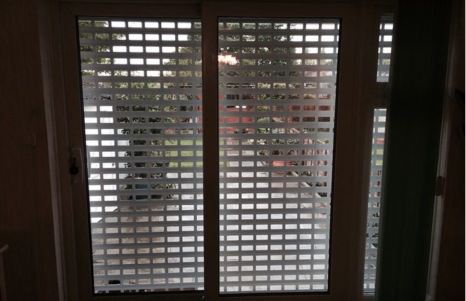 RSG5100 domestic shutter with 77mm punched laths in a brick bond style securing rear patio door in Greenford, Middlesex.